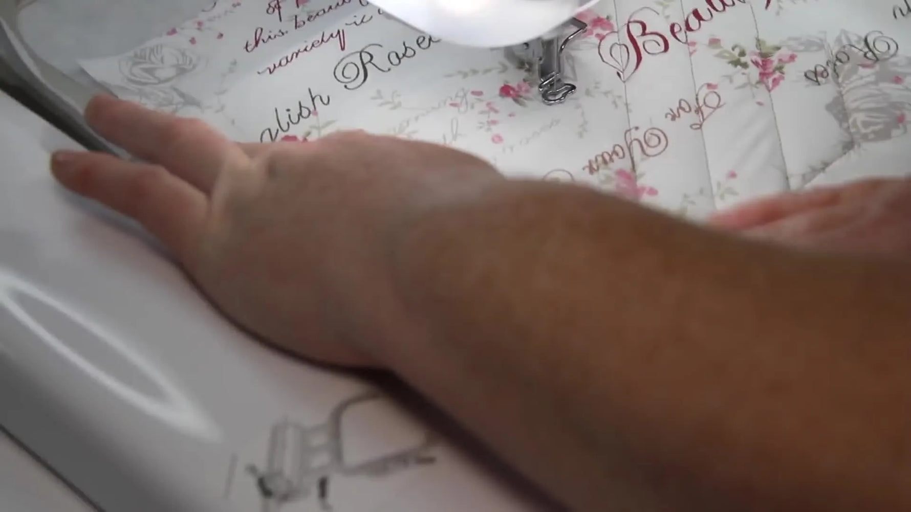 Embroidery machine stitching a quilting pattern on the main fabric