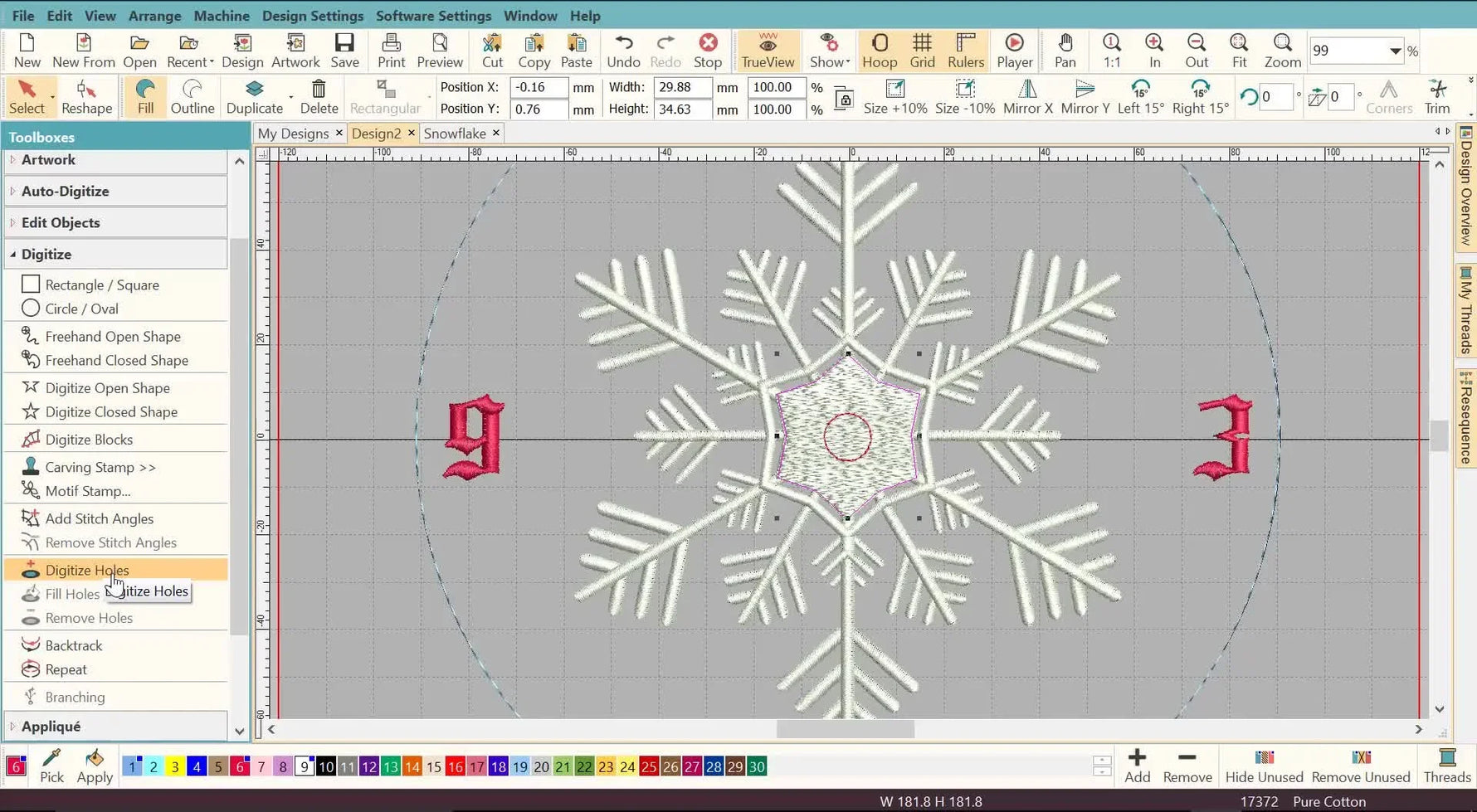 The finished digitized snowflake clock face is shown centered in the hoop grid, with the numerals aligned and a clean center hole ready for the clock mechanism.