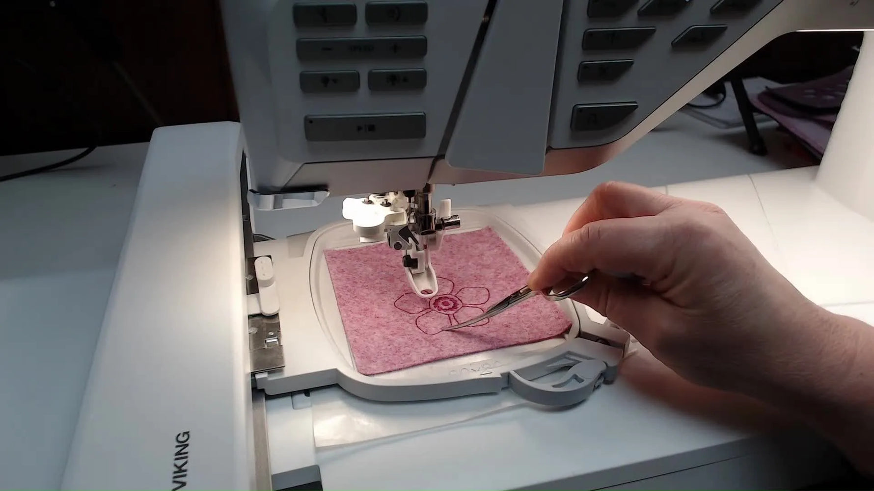 A close-up of the cutwork needle piercing felt as the machine performs the cutting passes.