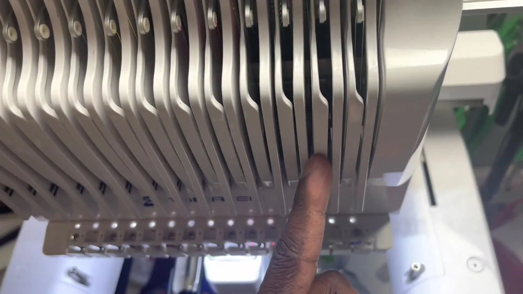 A clear mid-shot of the Romaker tension assembly showing the thread traveling down the main tension channels for a clean, break-resistant path.