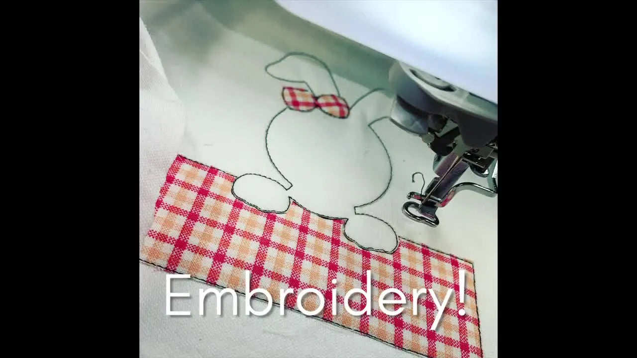 Close-up of an embroidery machine stitching a bunny design on plaid fabric.