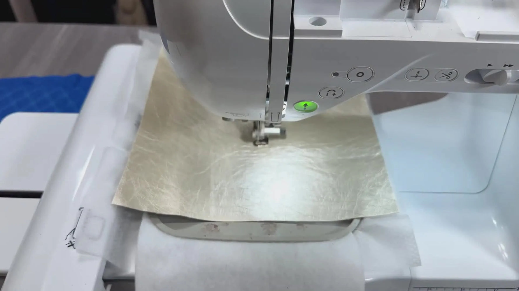 The finished diamond-quilted faux leather panel is still in the hoop on the Brother SE1900, catching light across the raised texture.