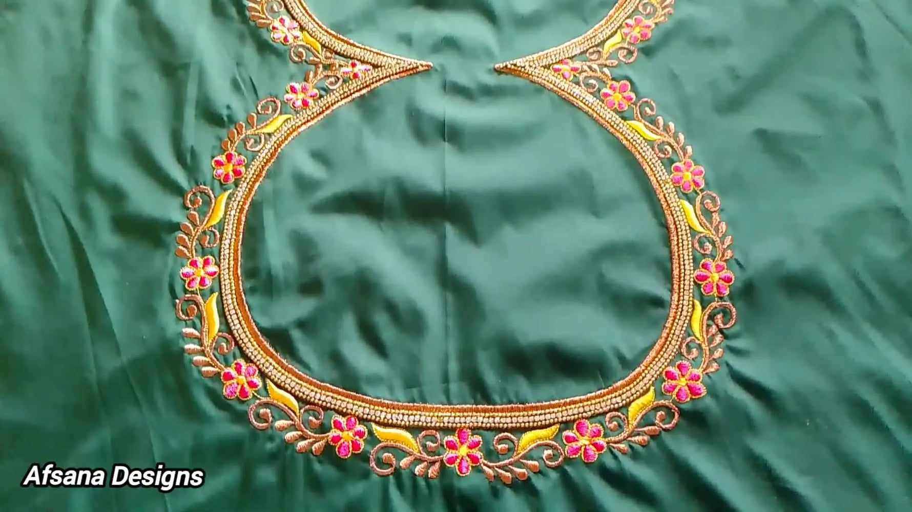 The finished green silk blouse neckline featuring a curved gold stone-chain border with pink floral motifs and gold vine details.