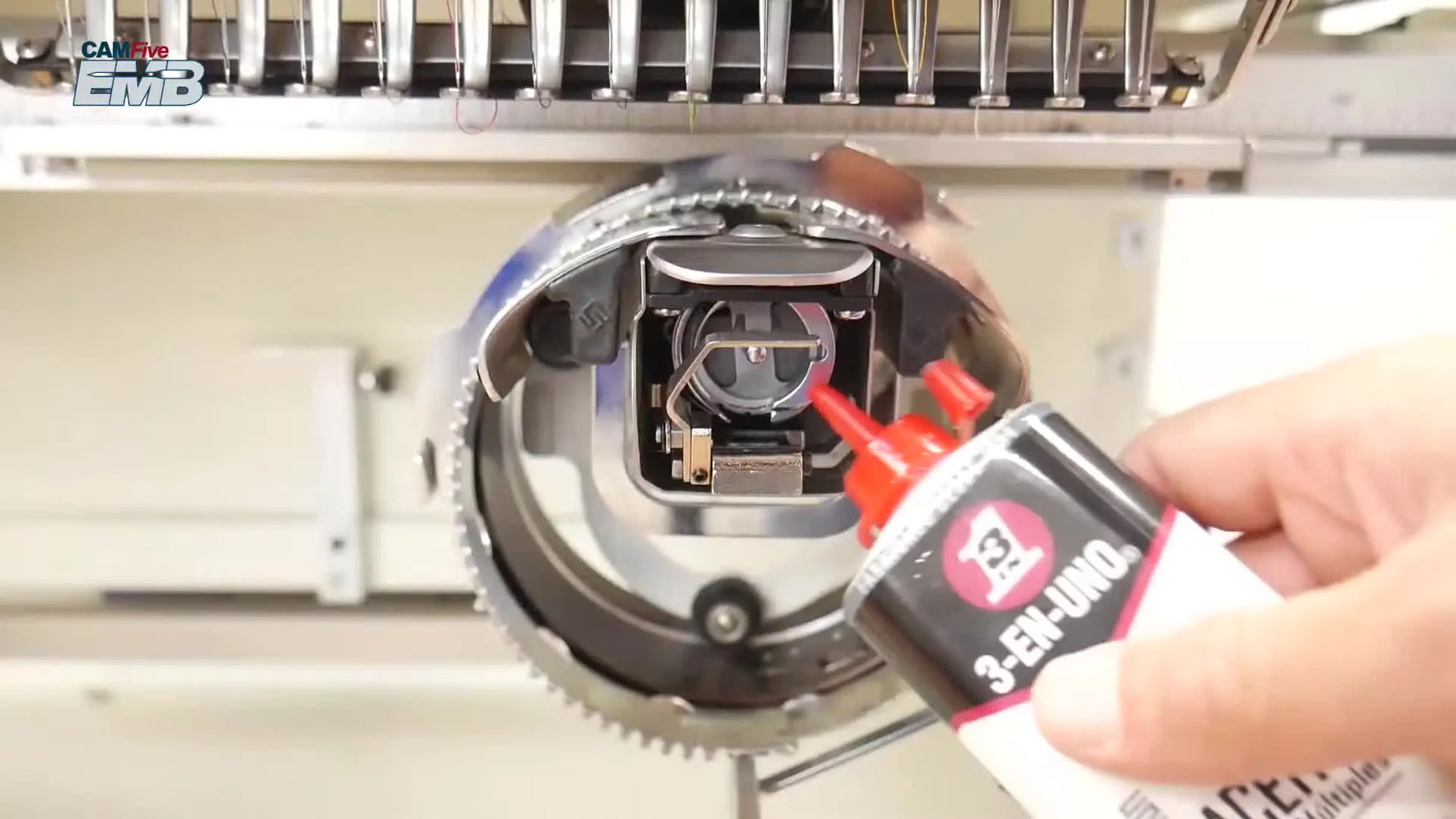 Close-up of oil being applied to the inner left race area of the CAMFive EMB rotary hook.