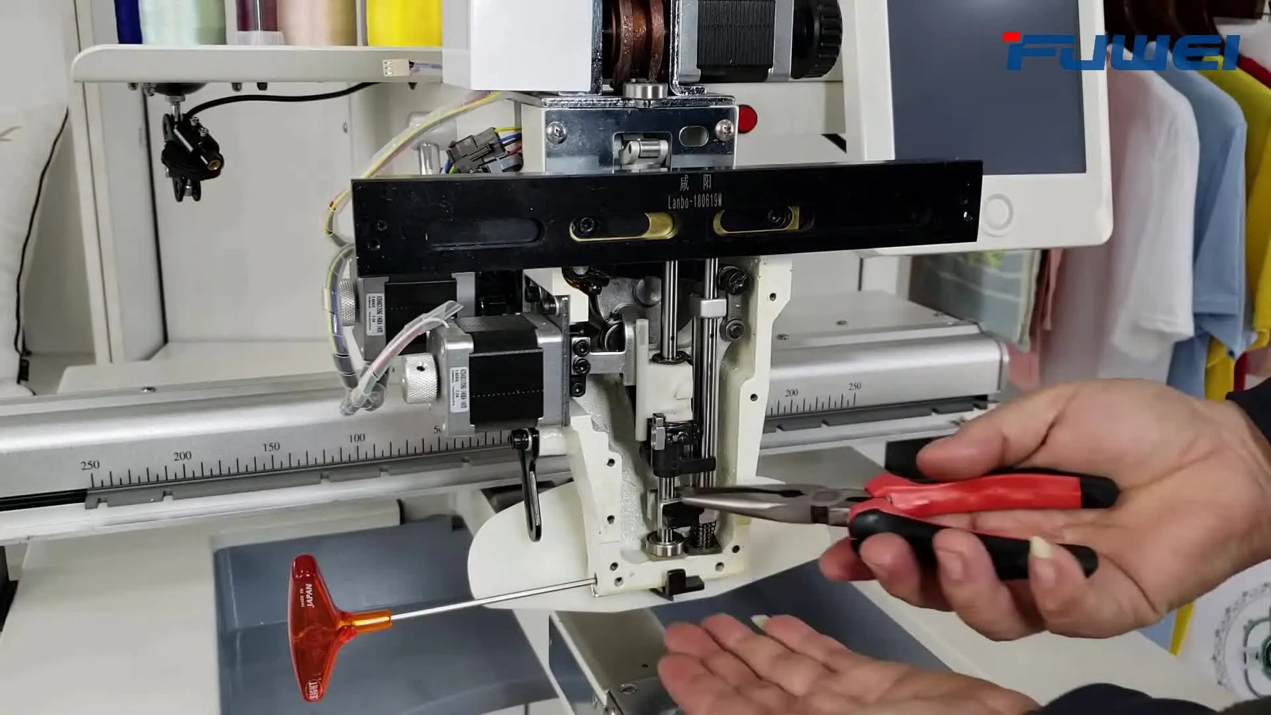 A technician holds the removed white plastic reciprocator in front of the FUWEI FW-1501 head, clearly showing the part that causes needle-bar drive issues when worn.