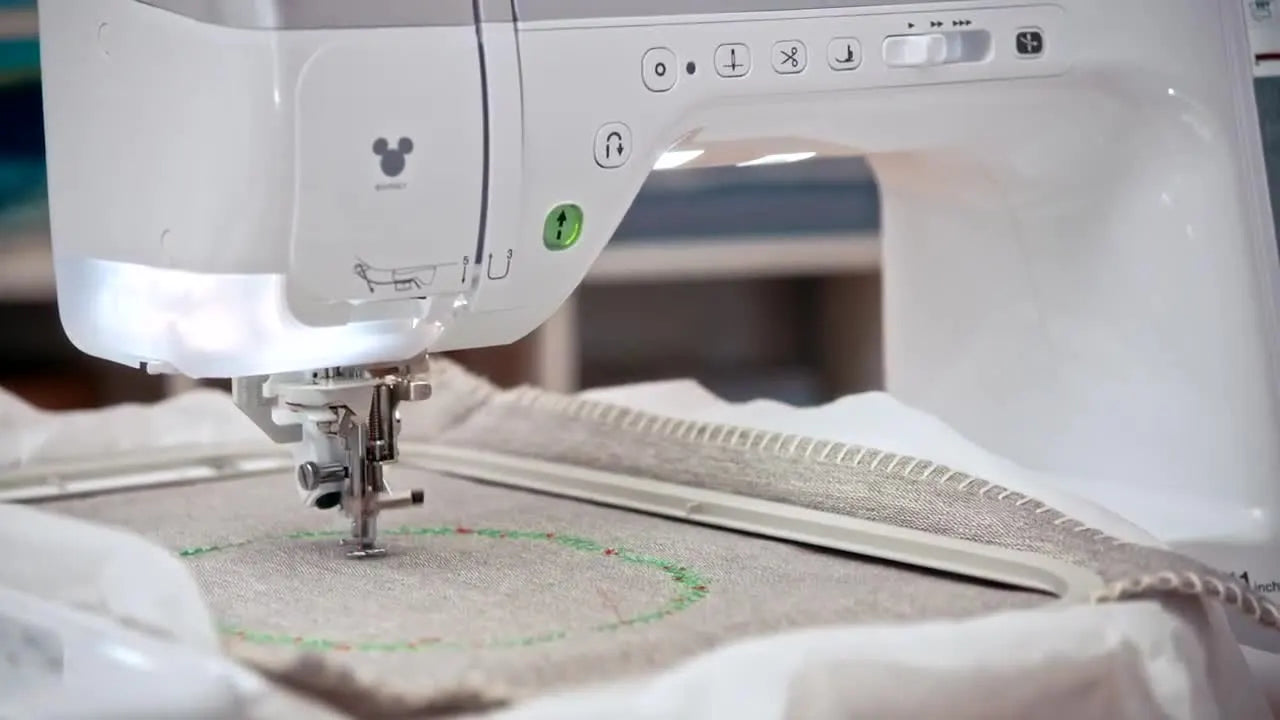 The Brother Stellaire embroidering a precisely positioned colorful design on hooped fabric.