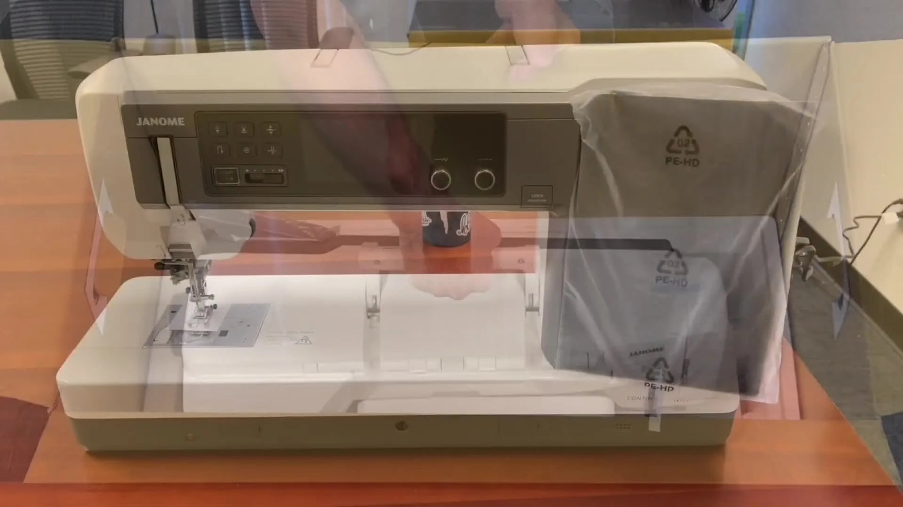 A wide shot of the Janome Continental M17 machine head being placed on a table during initial setup.