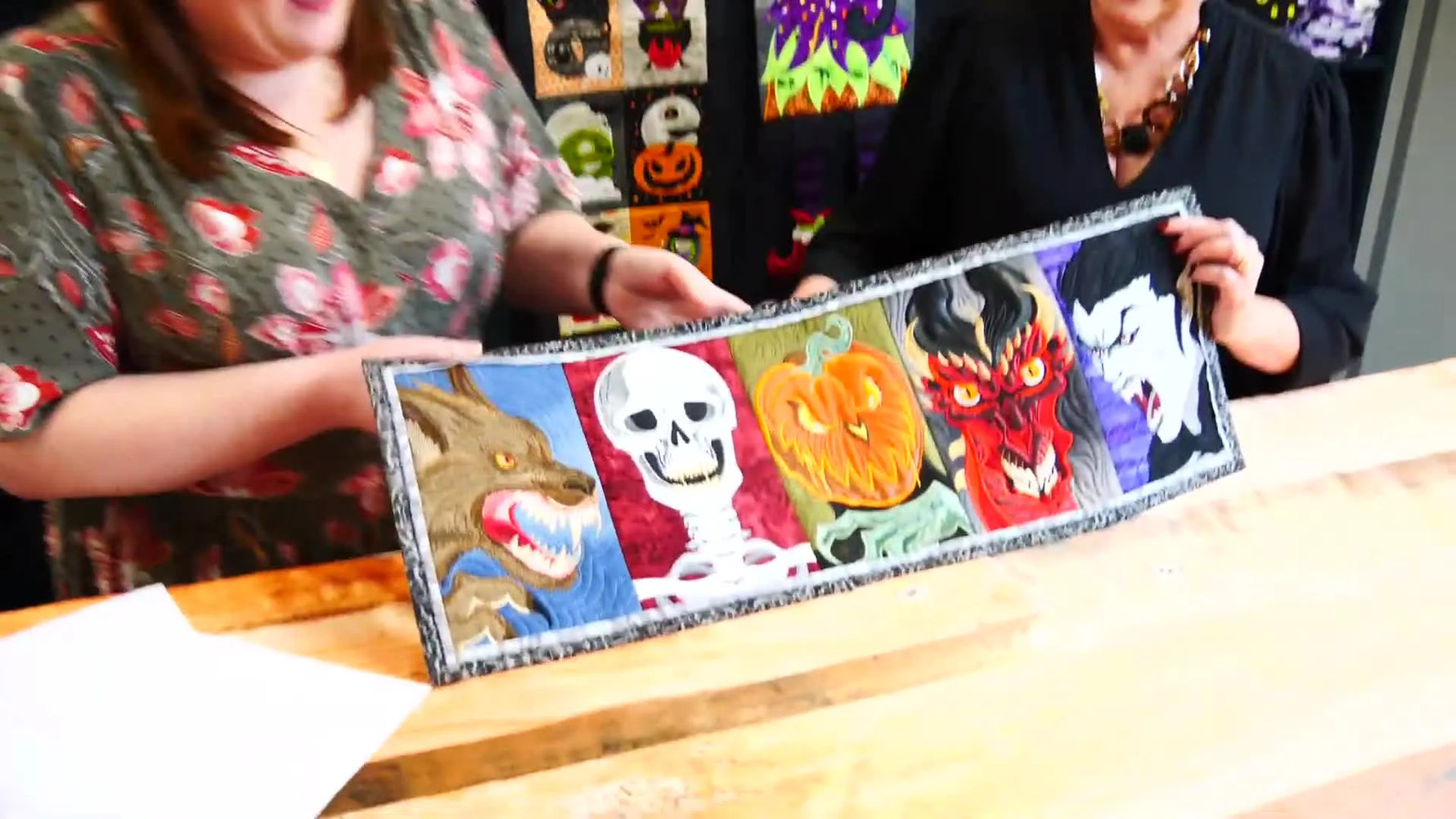 Anna and Emma hold the full Halloween Monster Runner open, showing all five realistic monster panels side by side.