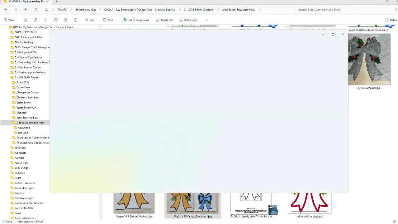 Close-up of the finished 5x7 holiday bow stitched in gold with holly and berries, showing the final look you’re aiming for.