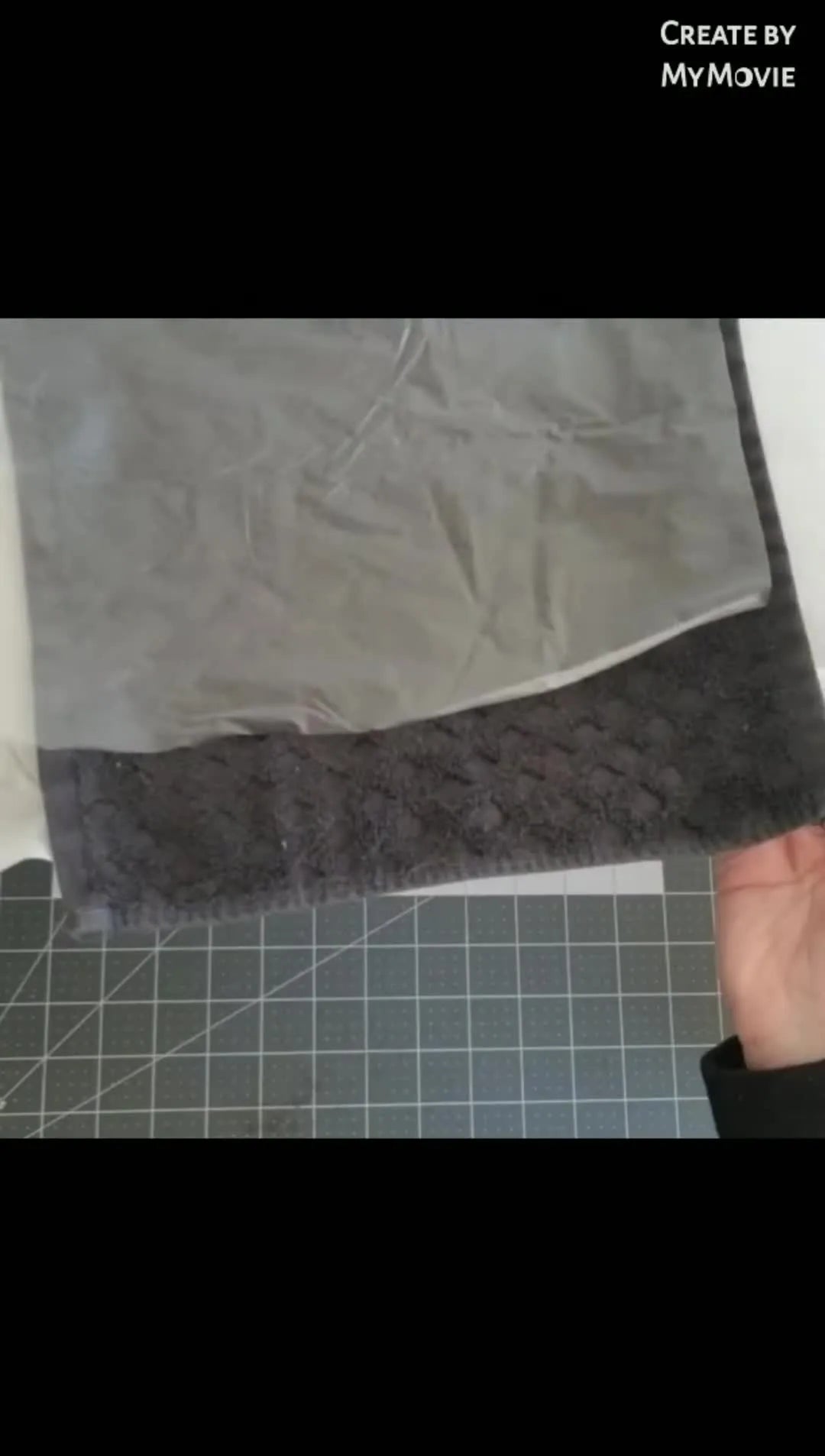 A fully prepared embroidery hoop holding a floated terry towel with a water-soluble topper on top, ready to mount on the machine.