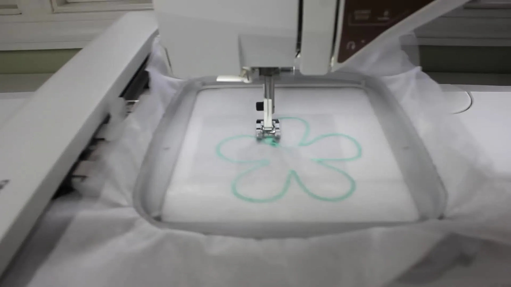 Embroidery machine stitching a flower design.