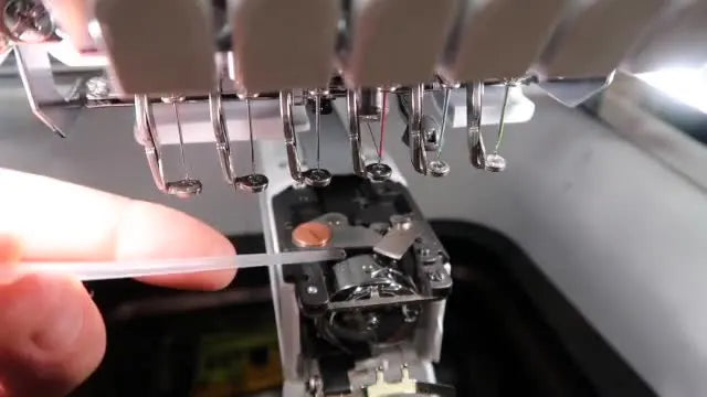 A top-down view shows a precise drop of oil placed between the blade arm and the race hook area for smooth rotation and cleaner stitching.