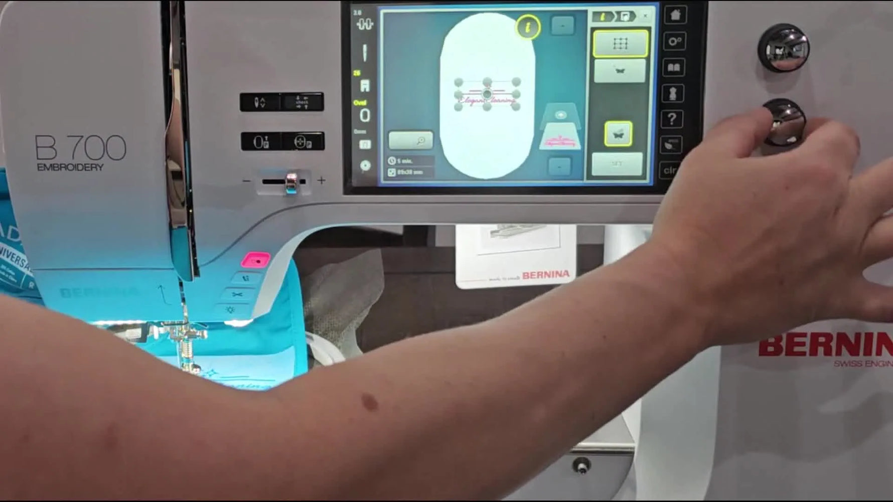 An extreme close-up shows the Bernina 700 needle lowered precisely onto the printed crosshair center on the target paper for perfect alignment.
