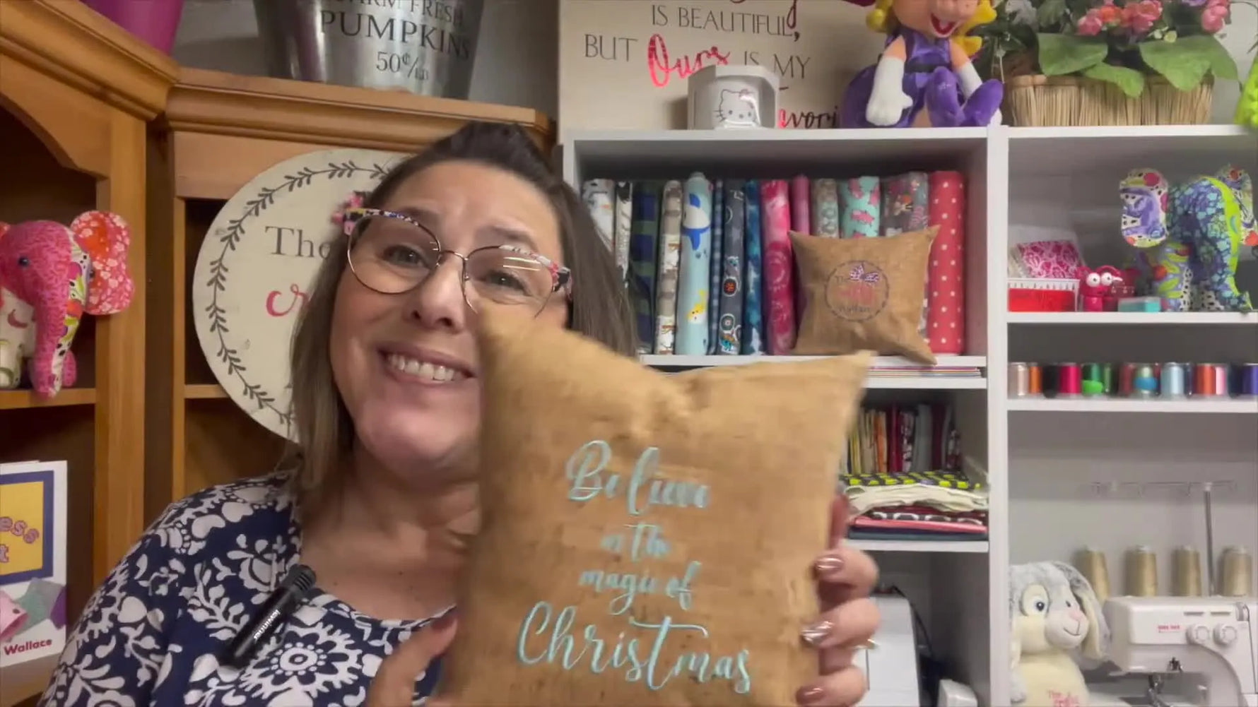 The finished cork pillow is held up to the camera, showing the embroidered “Believe in the magic” design on the front.