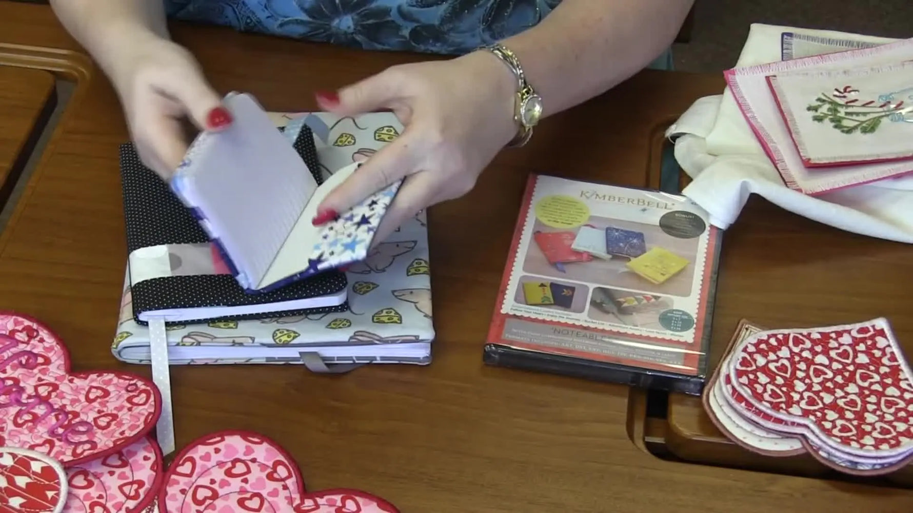 An overhead view of a pink-and-white heart-shaped in-the-hoop table centerpiece with dense quilting textures and segmented heart blocks.