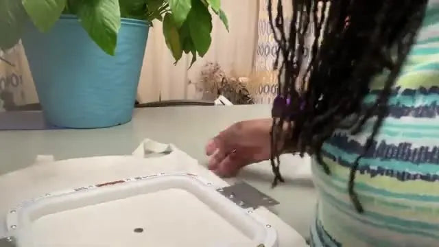 A perfectly centered magnetic hoop sits on a tote bag with the placement sticker aligned to the hoop’s center mark.