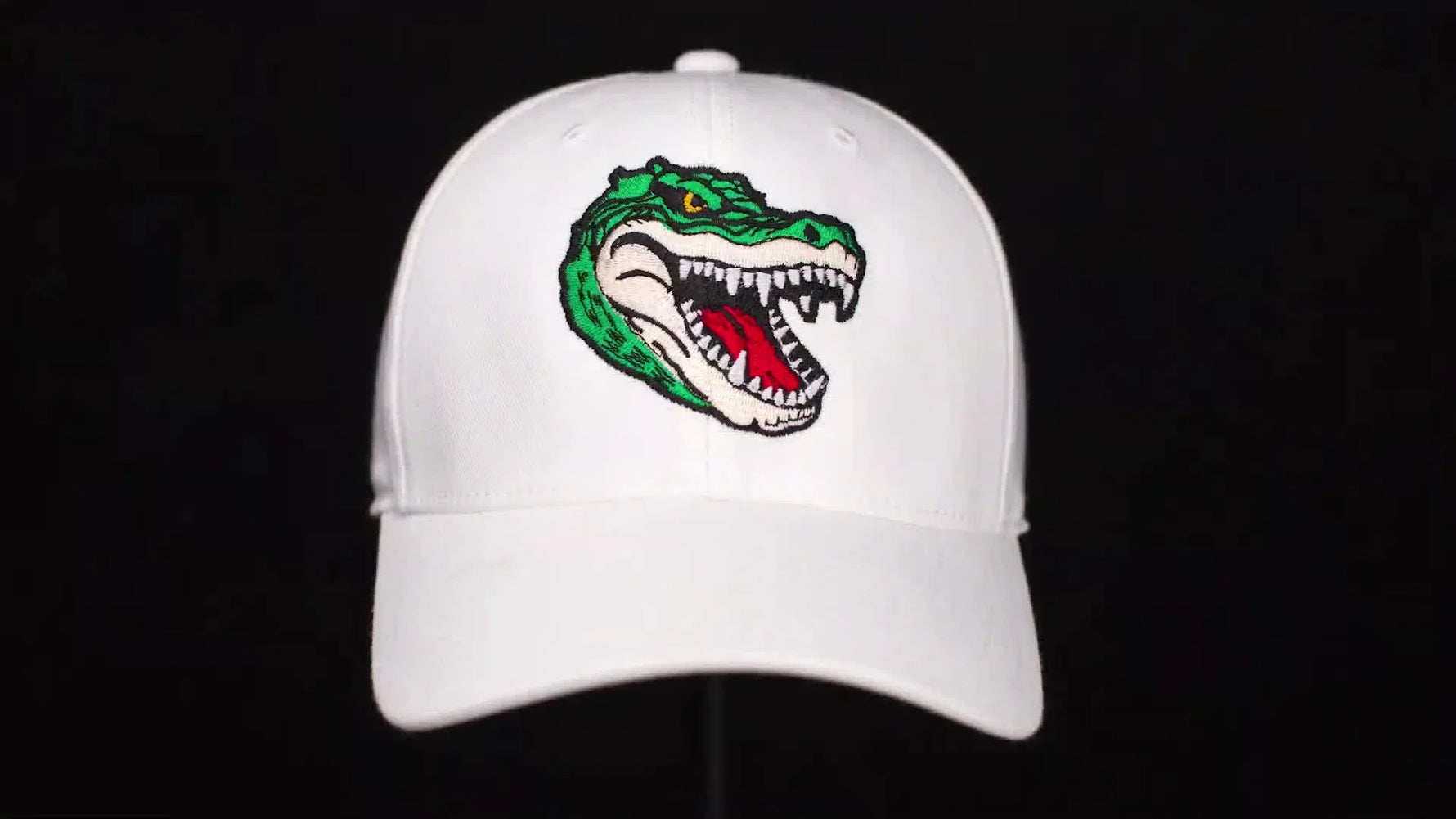 A clean front-view reveal of the finished white cap with a crisp, gap-free crocodile embroidery design.