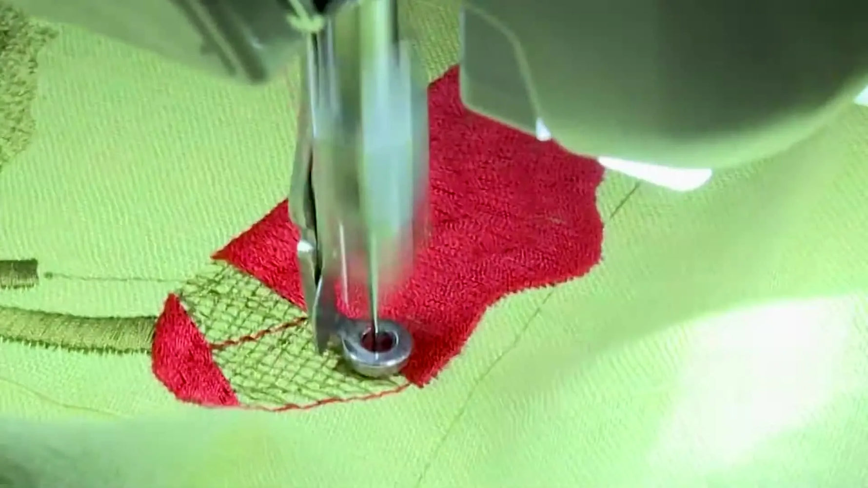 A close-up of red satin stitches wrapping cleanly around an Edge Walk underlay line, showing how the outline stays tight and accurate.