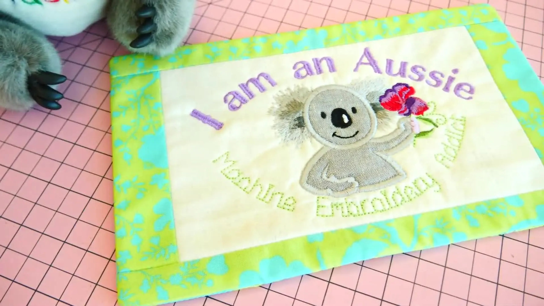 The finished “I am an Aussie” koala mug rug is displayed beside a stuffed koala toy in a neat flat-lay reveal.