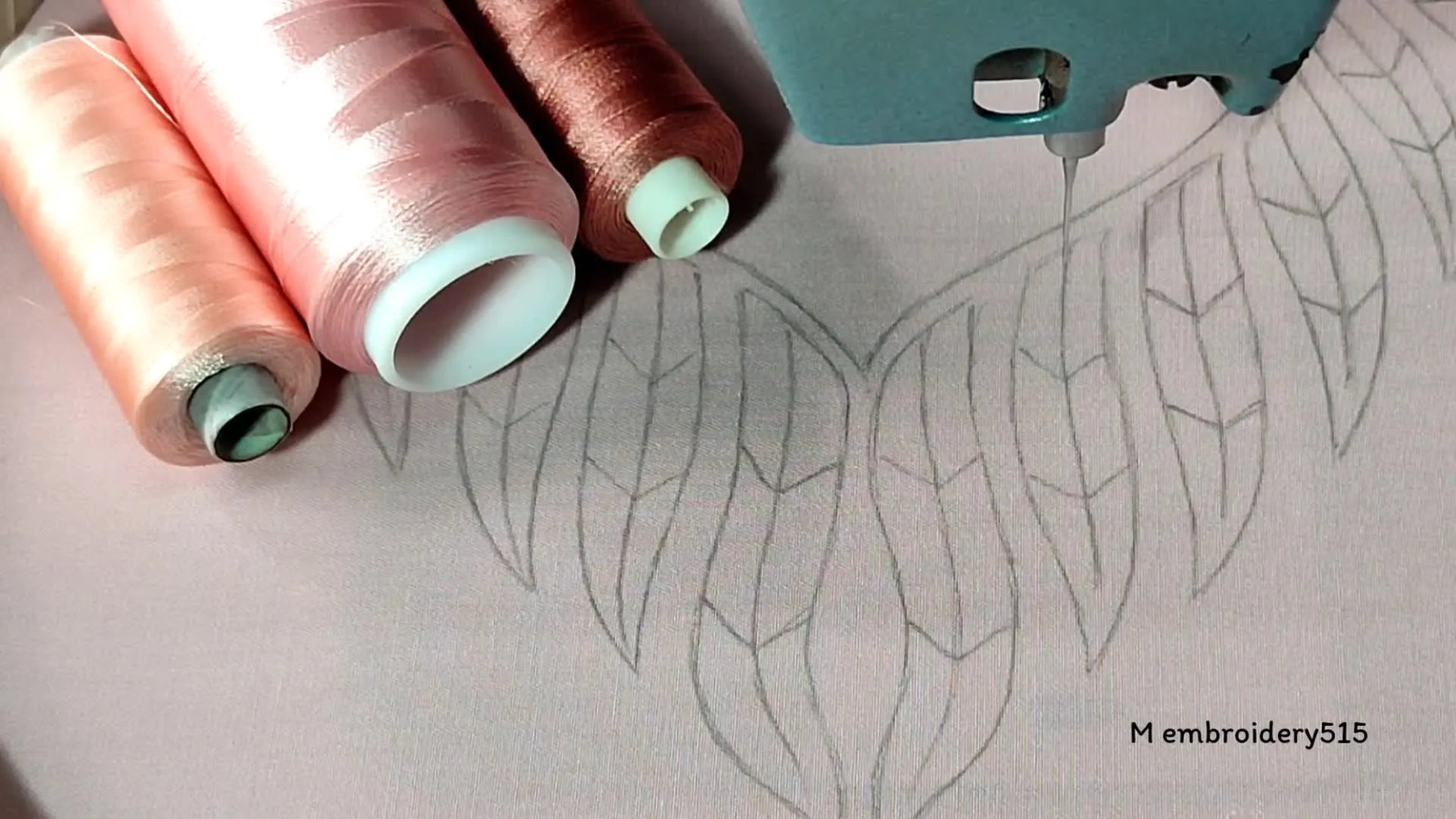 Embroidery setup with drawn neckline design and thread spools