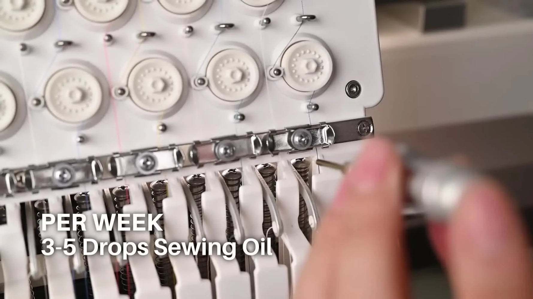 Hand using an oiling pen to lubricate the needle bar