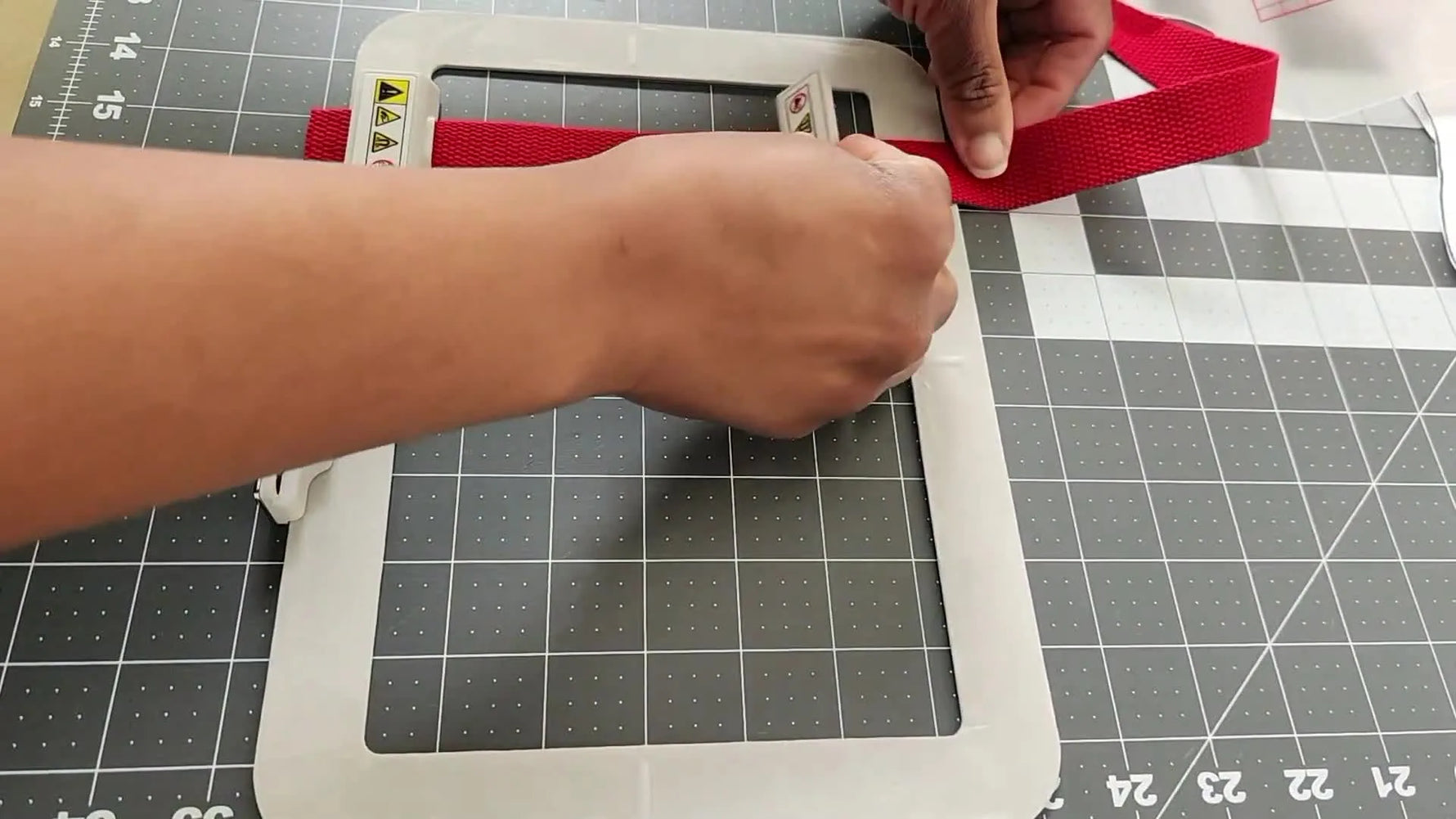 Overhead view of rectangular magnets securing 1-inch webbing inside the SA444MK 5x7 magnetic hoop for a slip-resistant stitch test.