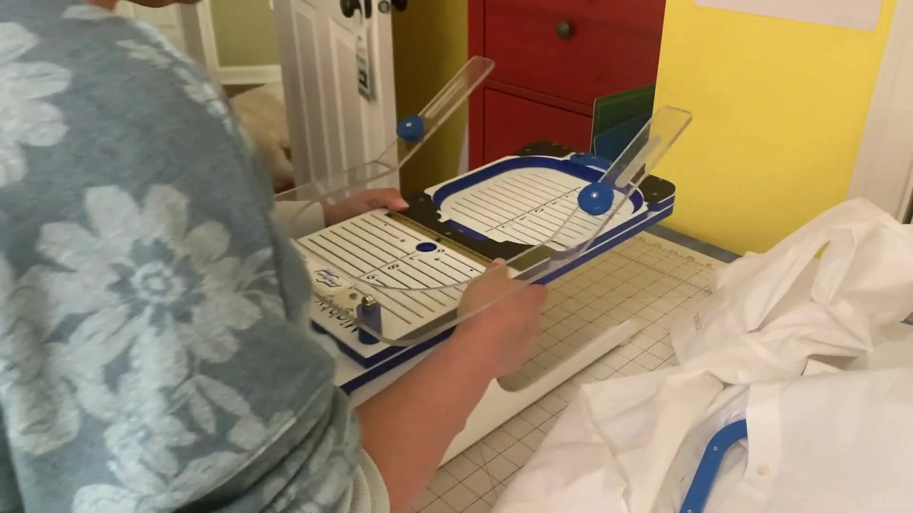 A men’s dress shirt is aligned on a hooping station grid with a magnetic hoop fixture, ready for precise hem monogram placement.