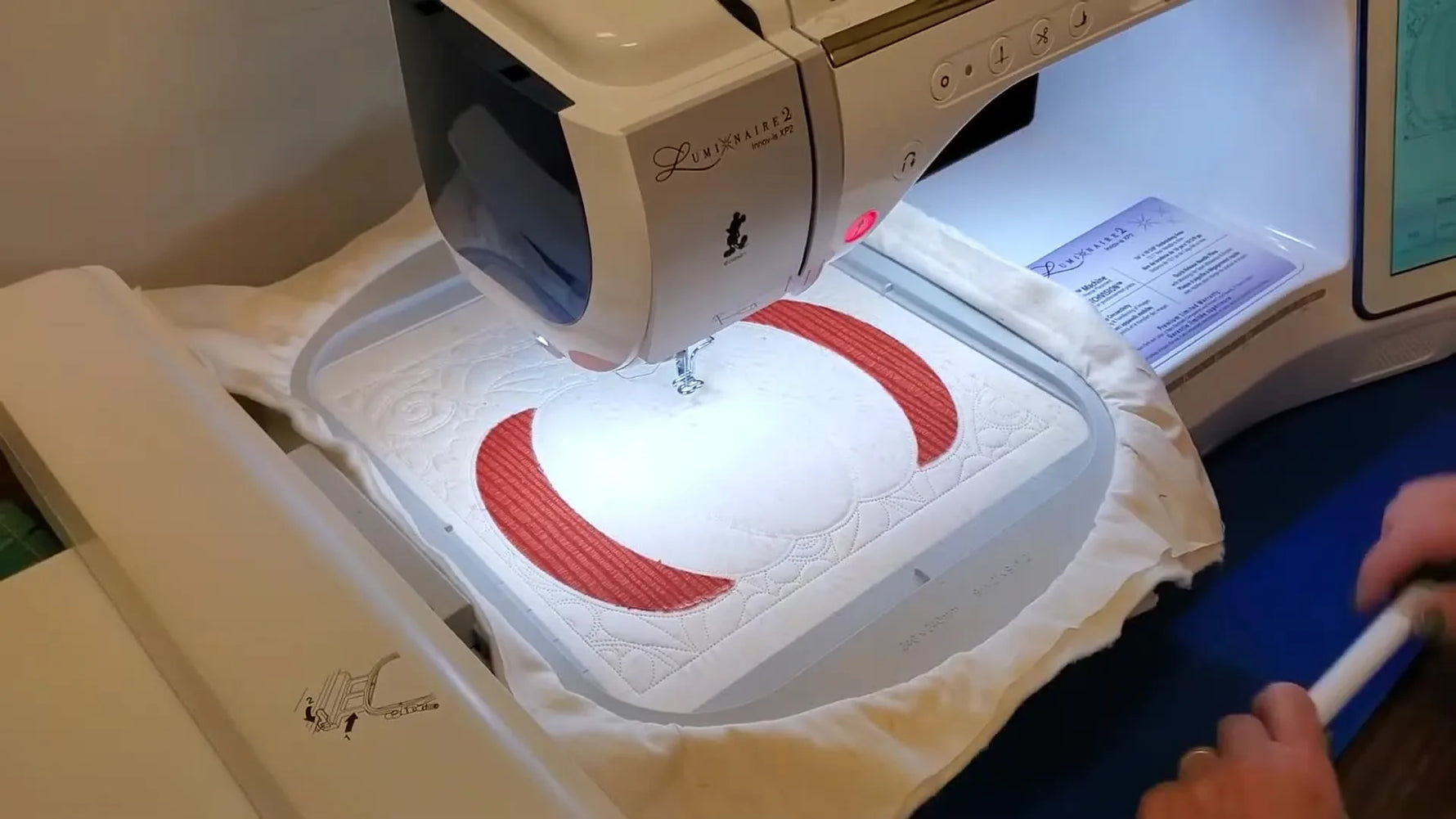 A close-up shows the embroidery foot stitching a neat blanket stitch right along the edge of the fused pumpkin appliqué.