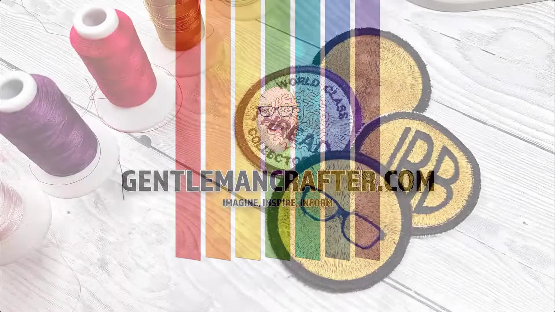 A spread of finished embroidered merit badges laid out on a white table beside colorful thread spools.