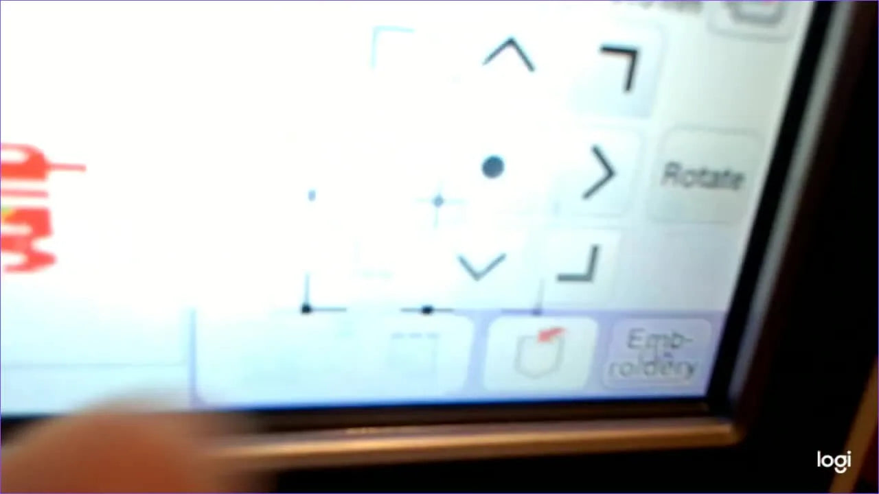 A close-up of the Brother LCD alignment grid as the operator presses the bottom-center needle-position check to verify perfect registration before stitching the second segment.