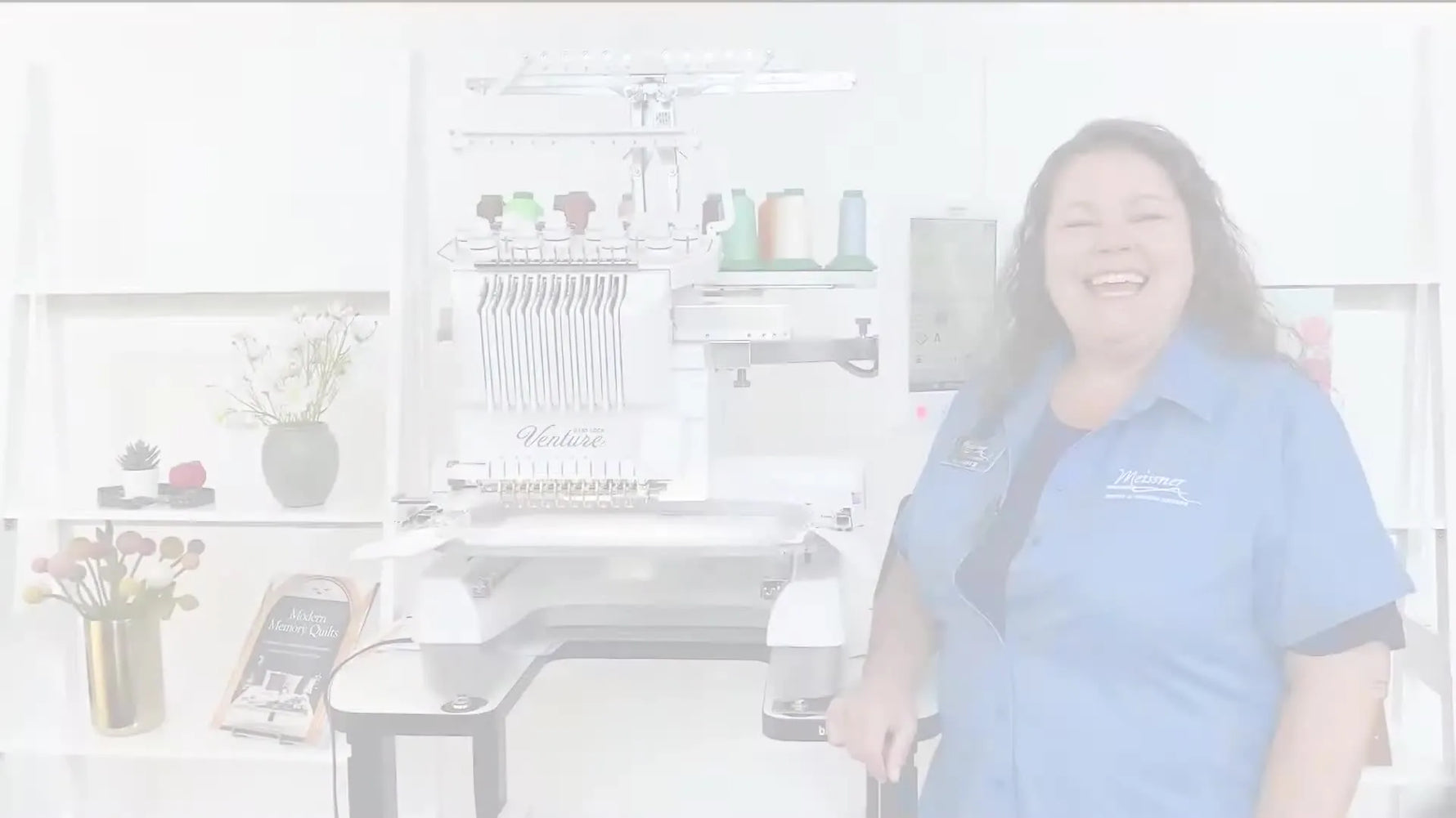 A presenter stands beside the Baby Lock Venture 10-needle embroidery machine, highlighting its multi-needle setup and large touchscreen.