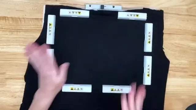 A black knit T‑shirt is held perfectly flat inside a Sew Tech magnetic hoop with eight white magnetic bars evenly spaced around the frame.