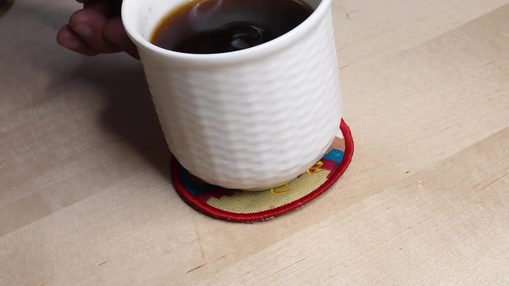 Finished in-the-hoop mug rugs (including a star version) styled beside a cup of coffee on a table.