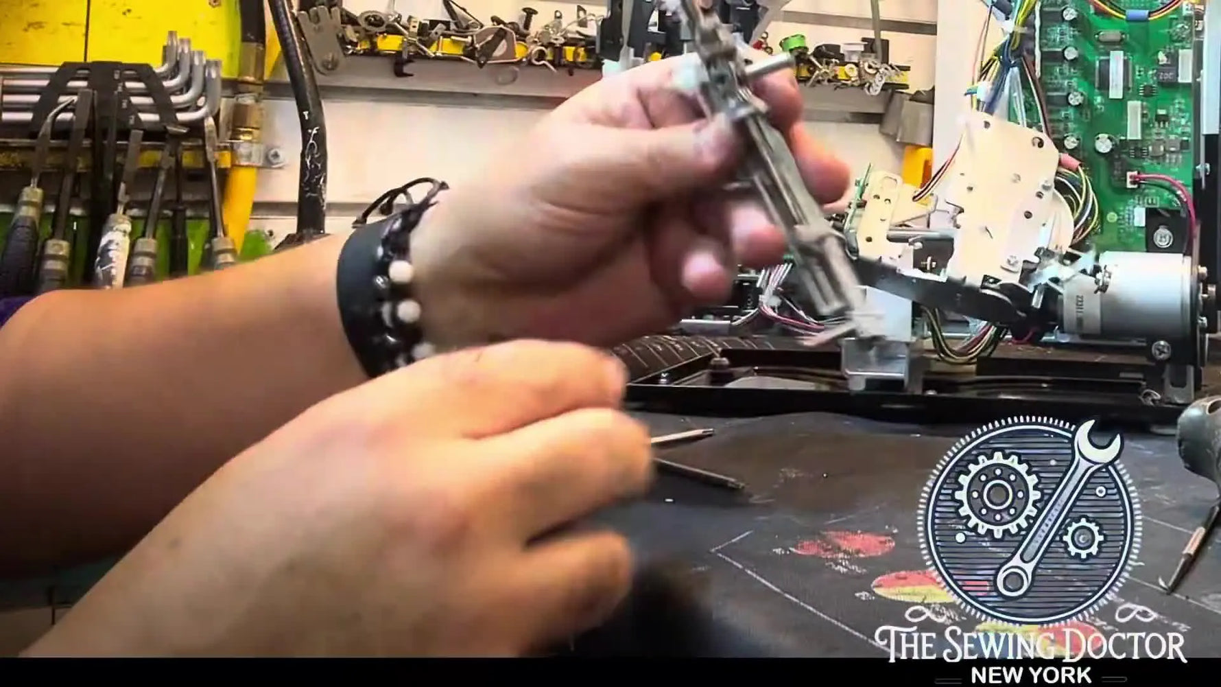 A close-up of the Singer SE9180 needle threader assembly showing the bent metal guide pin that caused the machine to seize.