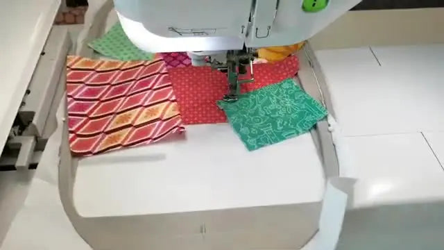A fully stitched star patchwork block sits inside the embroidery hoop, showing crisp seams and complete fabric coverage before trimming.