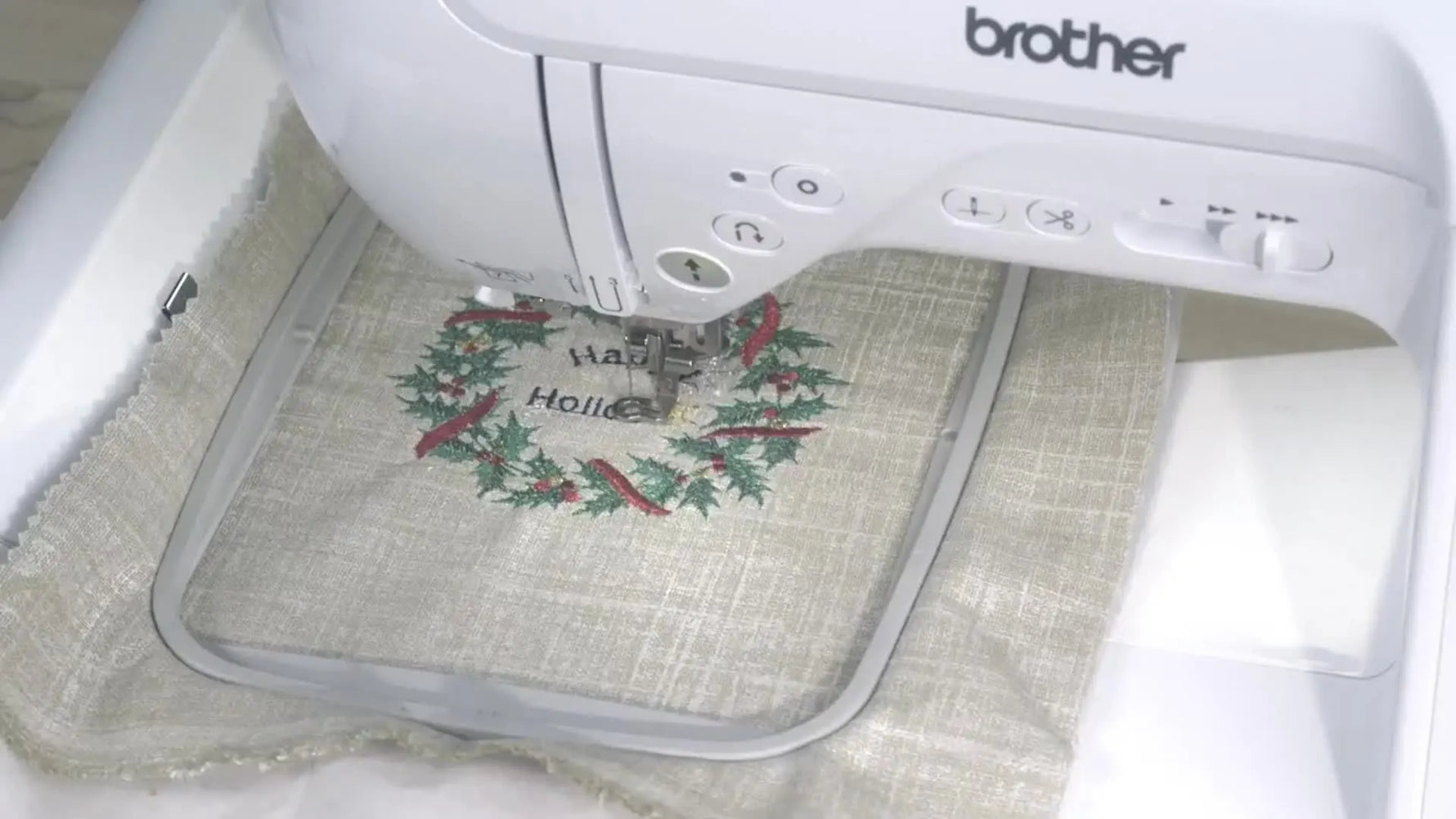 A front view of the Brother PE800 with a 5x7 hoop holding a finished floral wreath sample, showing the machine’s embroidery-only layout and typical project scale.