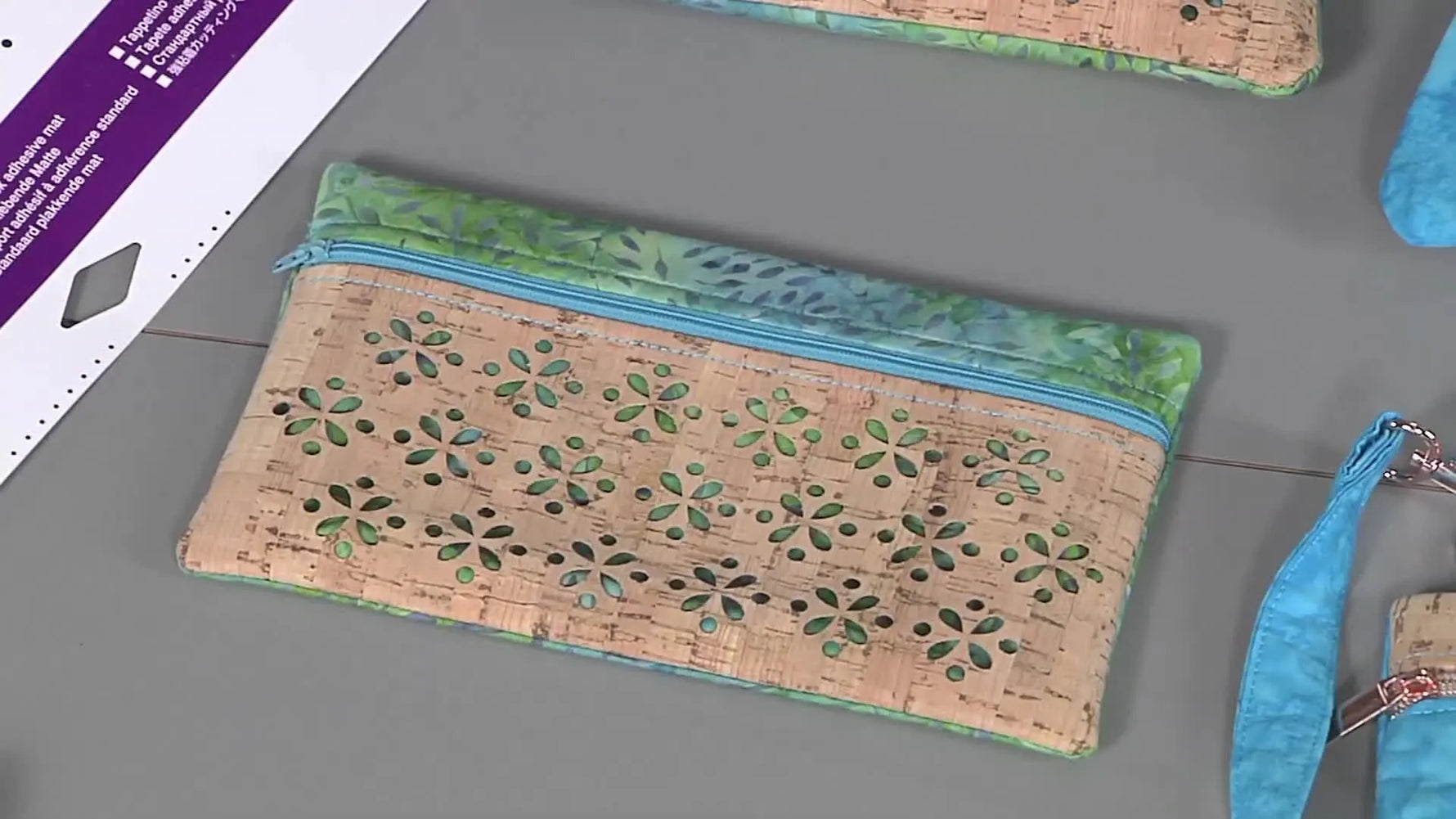 A finished in-the-hoop cork tote bag with a neat zipper and crisp cutout panel displayed flat on a table.