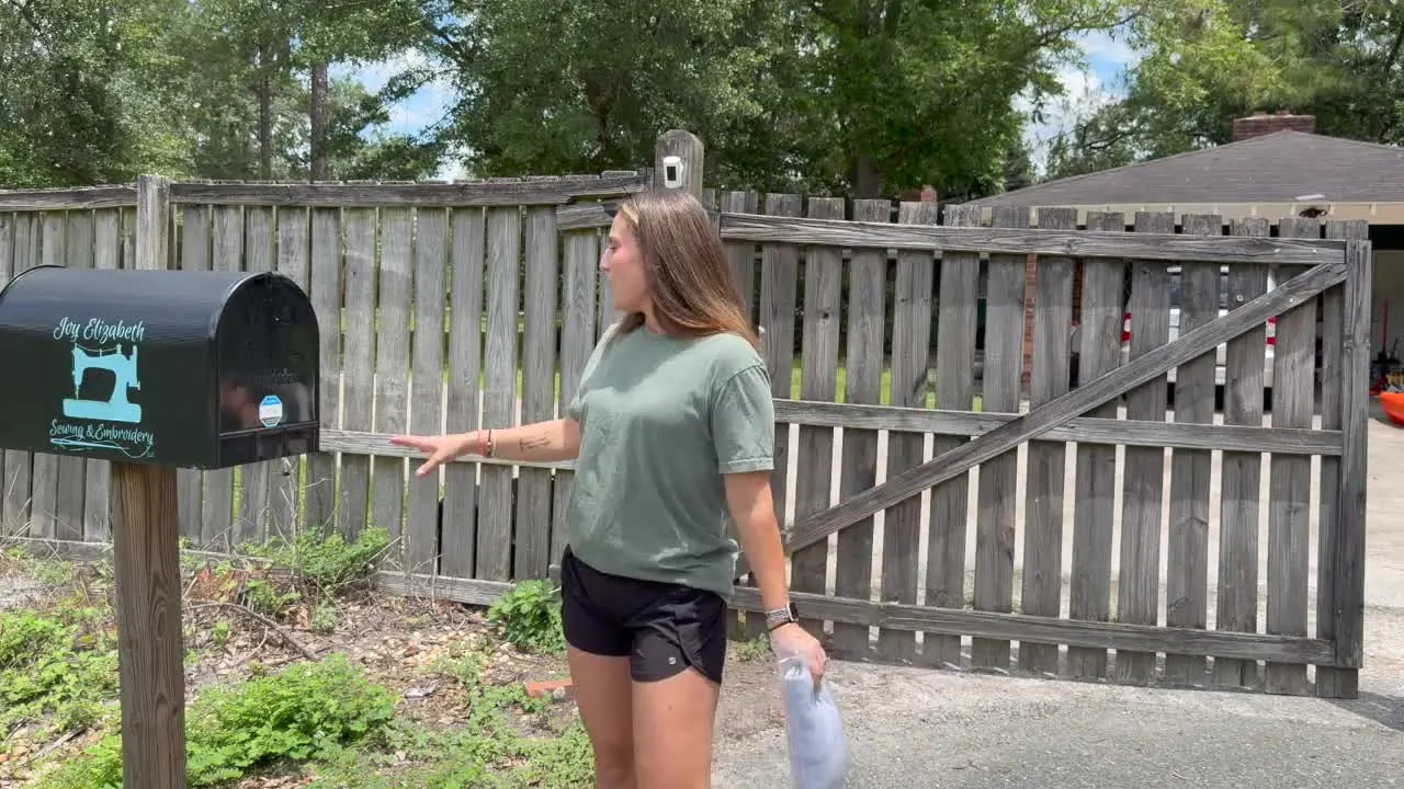 A close-up of a branded black extra-large mailbox used as a secure roadside pickup and drop-off station for embroidery orders.