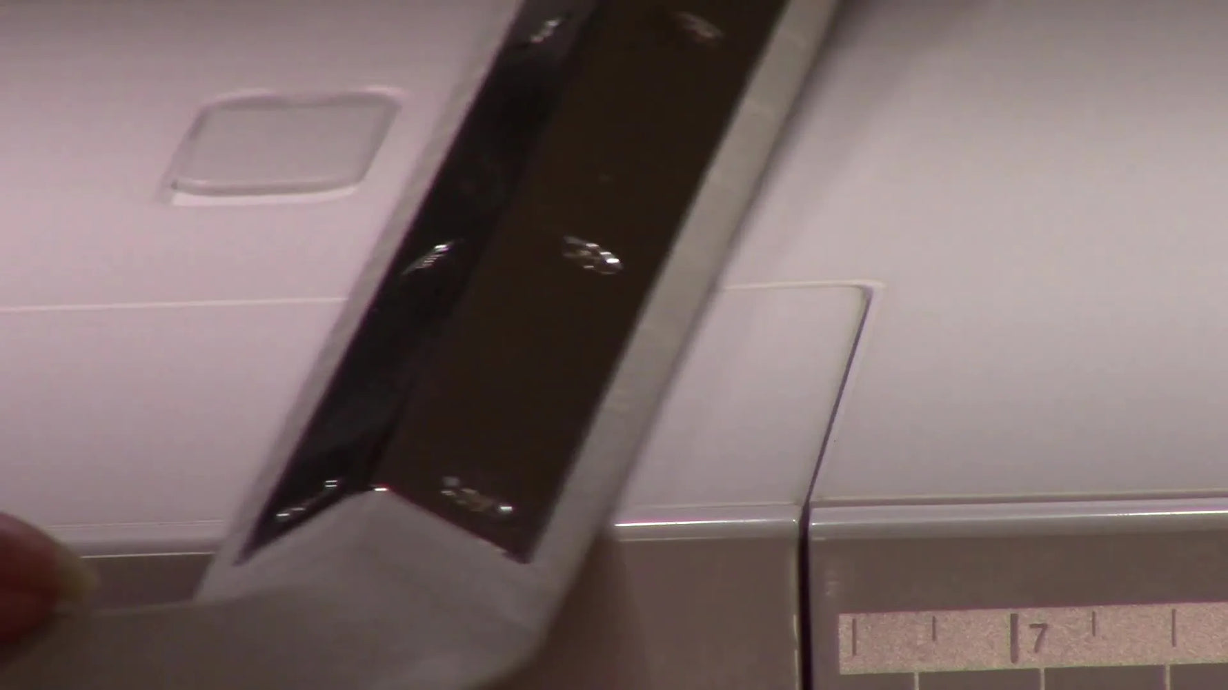 Close-up of the underside of a magnetic hoop showing scuff marks that reveal where it has been catching on the machine bed seam.
