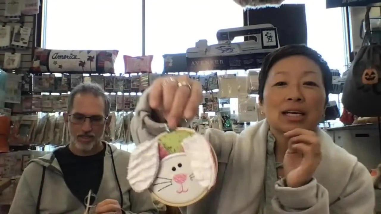 A close-up of the finished “I’m All Ears” bunny face hoop project, showing the applique details and plush minky texture.