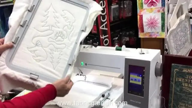 A close-up of the extra-large RE36b hoop holding a quilt block with batting, showing the Janome 550E’s large embroidery field in real use.