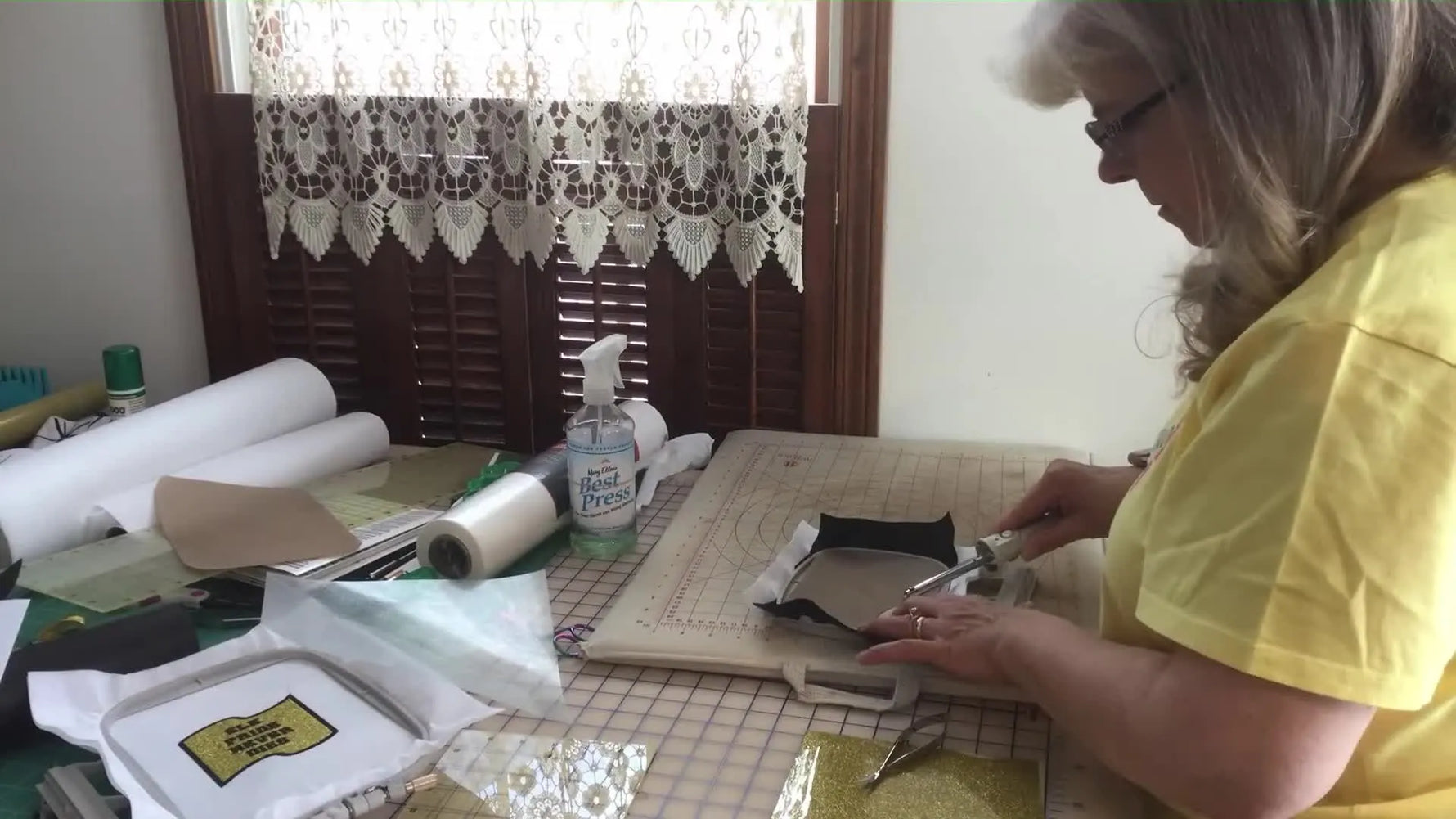 A close-up of a hot knife trimming a four-leaf clover patch edge to seal and cleanly cut the shape.