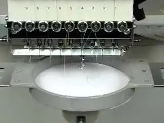 A close-up of an unthreaded needle perforating cardstock to create a clean appliqué template outline.