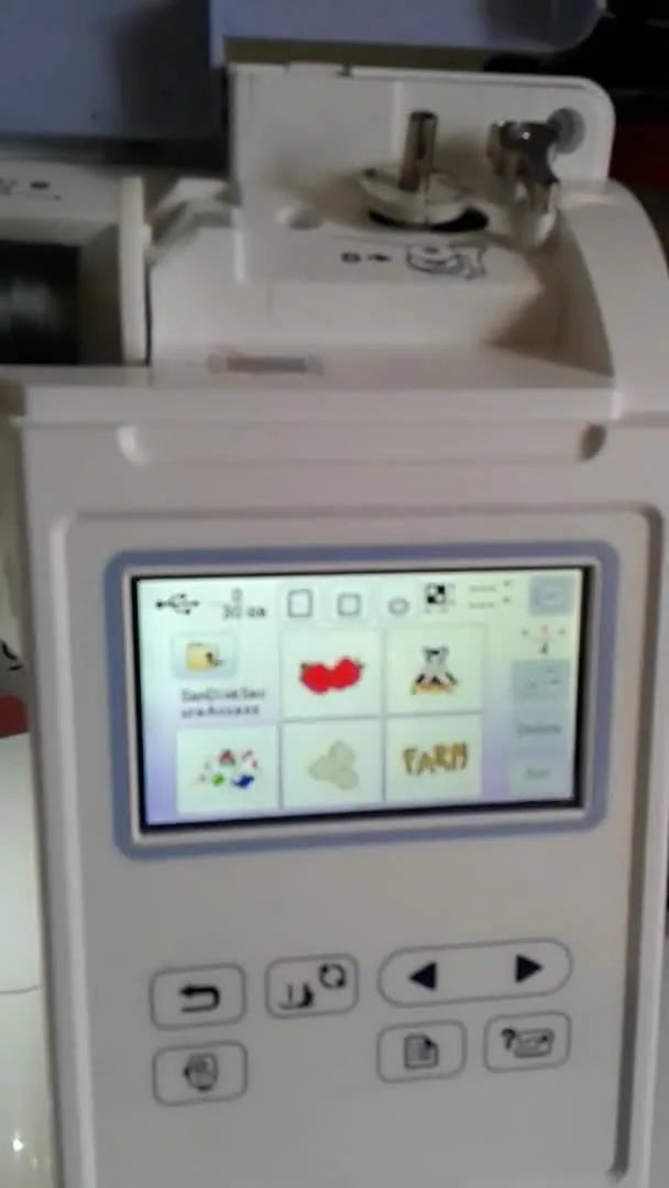 Close-up of the Brother PE800 home screen showing the main icons for USB, frames, and fonts.
