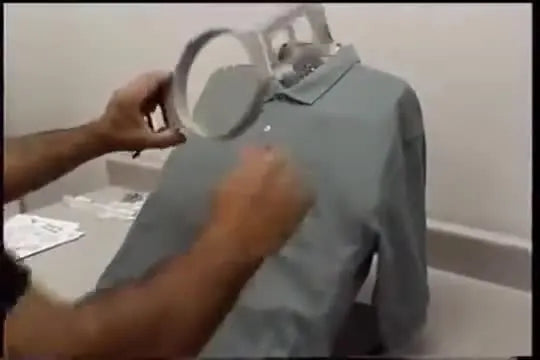 An operator presses the top hoop firmly onto a knit shirt mounted on the All-In-One Hooper for straight, repeatable placement.