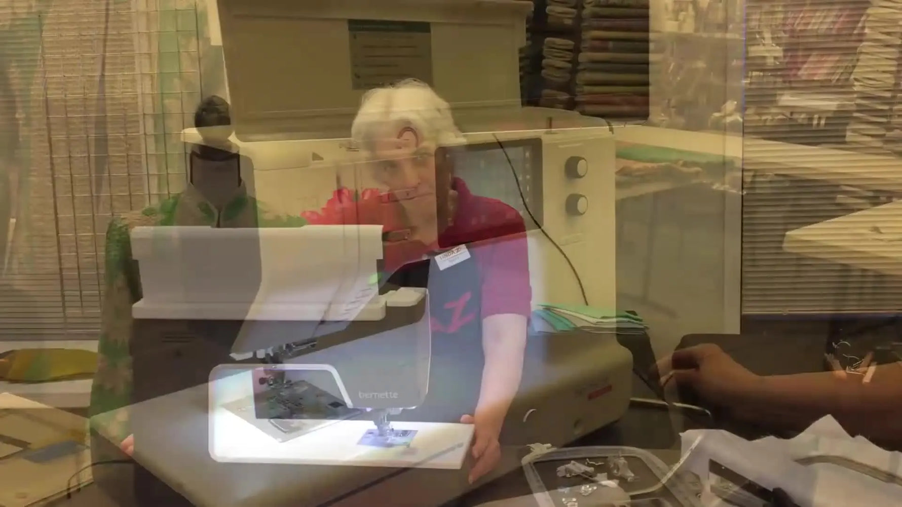 Mary stands beside the illuminated Bernette b79, setting up a hands-on look at the machine’s sewing and embroidery capabilities.