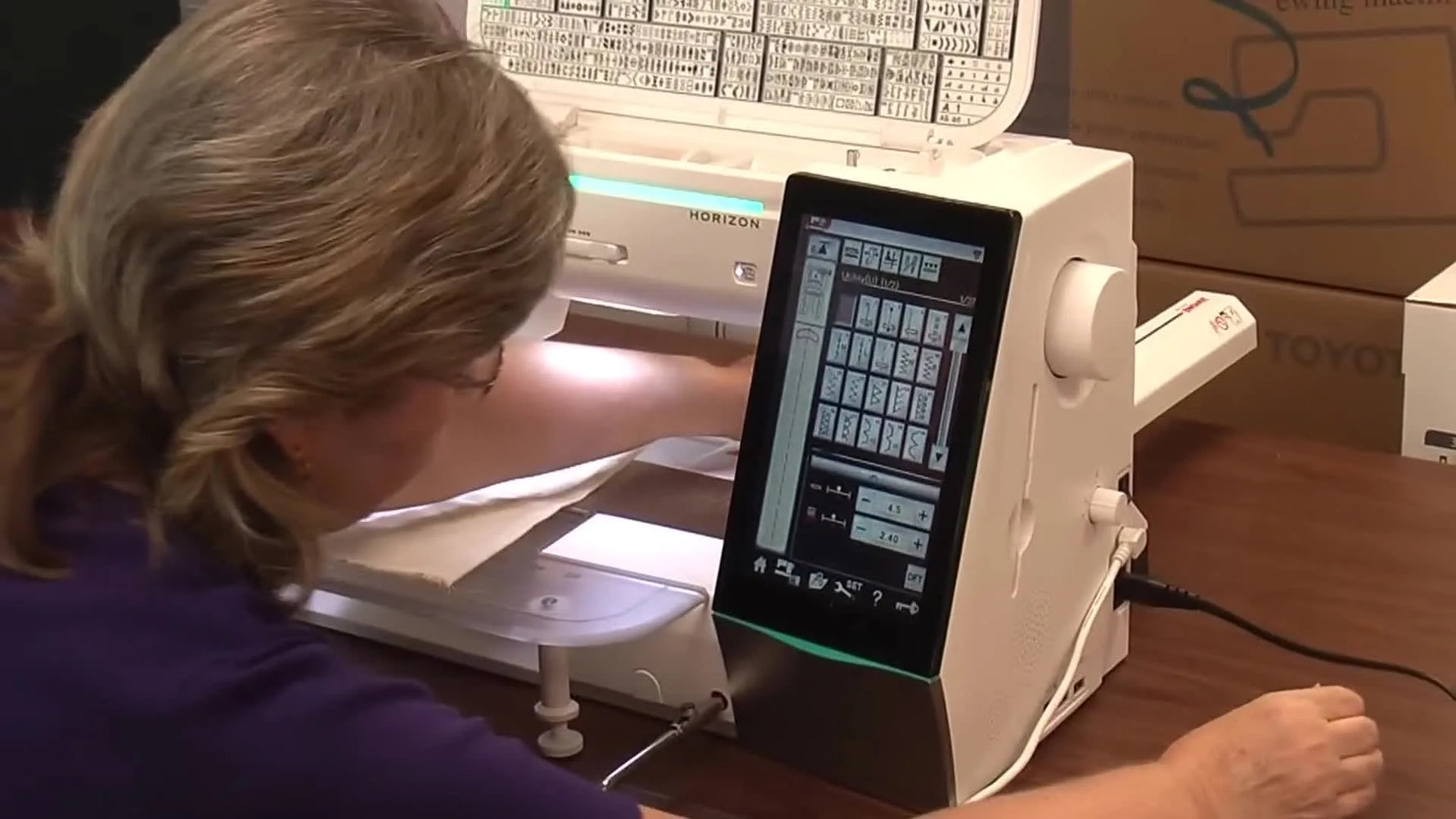 A dealer demonstrates extending the Janome Memory Craft 15000 embroidery unit (robotic arm) to convert the machine from sewing to embroidery mode.