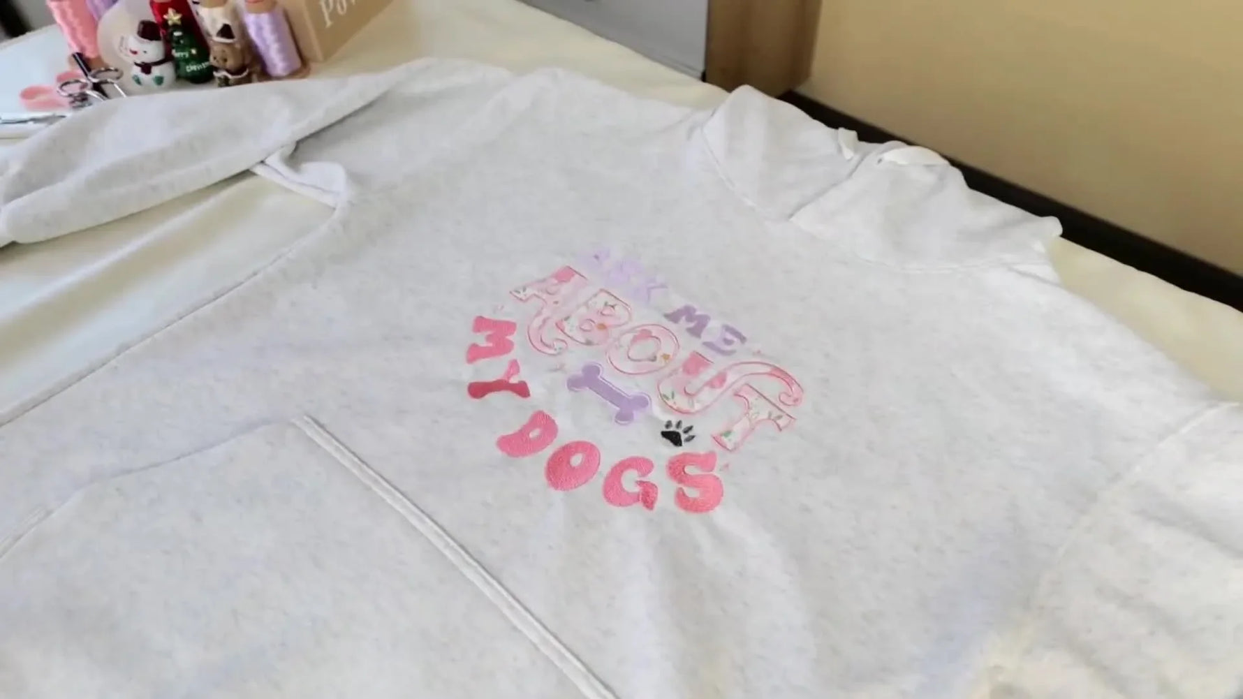 A full view of the finished grey hoodie featuring a large floral appliqué design with clean satin-stitched borders.