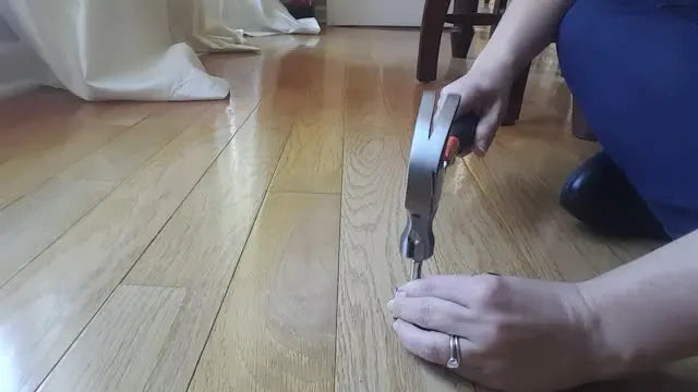 Overhead action shot of a hammer striking the setter tool to set a metal eyelet into an ITH fabric project.