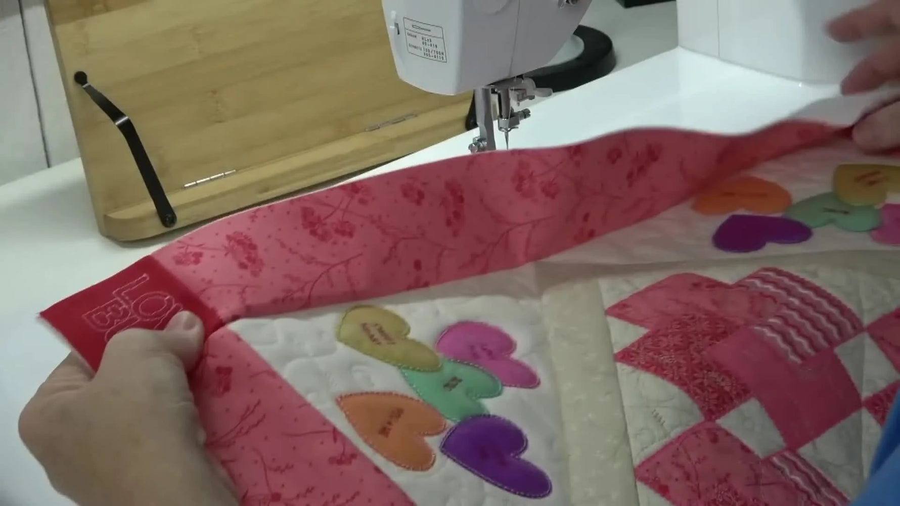 The fully assembled Love Bug table topper top is laid out flat, showing the heart blocks, inner borders, and outer borders before binding.